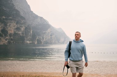 Elinde fotoğraf makinesi olan bir fotoğrafçı Alplerdeki mavi gökyüzüne karşı kar dağlarının fotoğrafını çekiyor. Seyahat tutkusu konsepti.