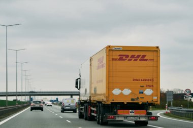 Polonya Avrupa 17.04.2023. DHL ekspres teslimat kamyonu otoyolda. Post DHL uluslararası kurye, paket ve ekspres posta hizmetleri sunar.