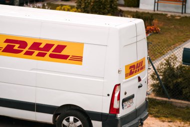 12 Temmuz 2023. Polonya, Avrupa. Banliyöye DHL teslimatı. Şirketin DHL için sembolik fotoğraf. DHL 'den (Deutsche Post International) bir paket teslimat minibüsü Polonya' da bir caddeye park edilmiştir..