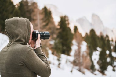 Alp Güzeli Yakalıyorum. Erkek fotoğrafçı, Kar Kapaklı Tepeler 'in Gezinti Anında profesyonel görüntülerini yakalıyor. Avrupa 'da tatil kavramı.