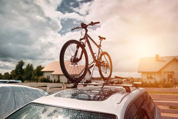 Bike transportation. Bicycles on the roof of a car against a beautiful sky. Transportation and logistics of large loads and travel by car. Summer vacation activities.