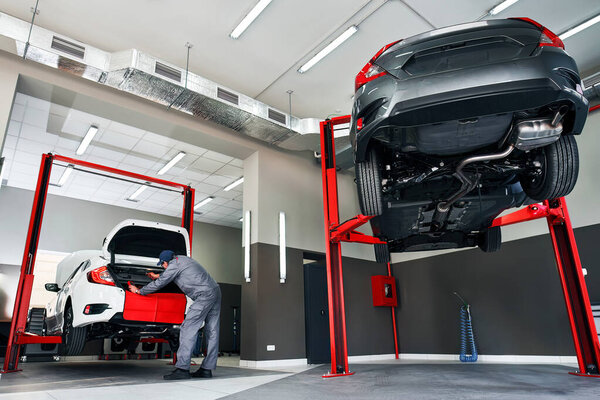 Expert Car Repair. Skilled Mechanic Conducts Maintenance in Service Panorama. Mechanic repairing a car.