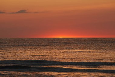 Parlayan güneş denizin ya da okyanusun ufuklarında batıyor.
