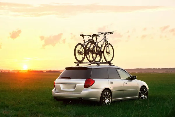 Bike transportation. Bicycles on the roof of a car against a beautiful sky. Transportation and logistics of large loads and travel by car. Summer vacation activities.
