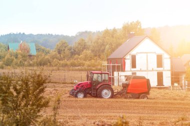 Sunset 'te traktör tarlaları. Hasat makinesini iş yerinde birleştirin. Tarım endüstrisi. Altın Saat Çiftçiliği.
