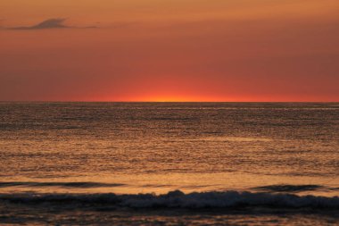 Parlayan güneş denizin ya da okyanusun ufuklarında batıyor.
