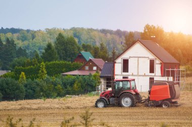 Traktör geniş tarlalarda sürerek tohumları saflaştırılmış toprağa ekecek özel yataklar yapıyor. Kırsal tarım arazisi. Tarım aracı kırsal kesimde gün batımında çalışıyor.