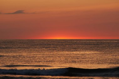 Parlayan güneş denizin ya da okyanusun ufuklarında batıyor.