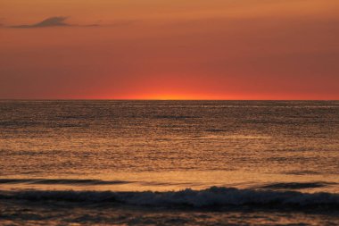Parlayan güneş denizin ya da okyanusun ufuklarında batıyor.