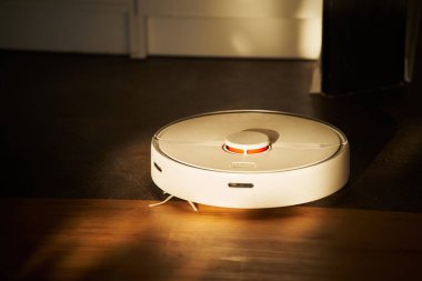 Akıllı Ev Temizleme: Robot Elektrikli Süpürge İçi. Robot elektrikli süpürge çalışıyor. İç güneş ışığı