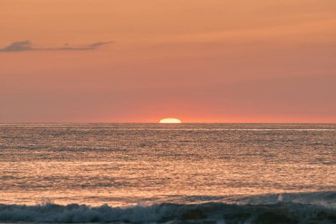 Parlayan güneş denizin ya da okyanusun ufuklarında batıyor.