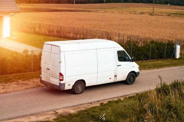 Beyaz minibüs. Modern teslimat küçük kargo kargo kurye minibüsü yolda ilerliyor. Teslimat kamyonu nakliye paketleri.