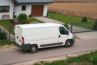 Verimli Beyaz Kargo Minibüsü hareket halinde. Modern Kargo Kuryesi. Yoldaki beyaz minibüs taşıma paketleri