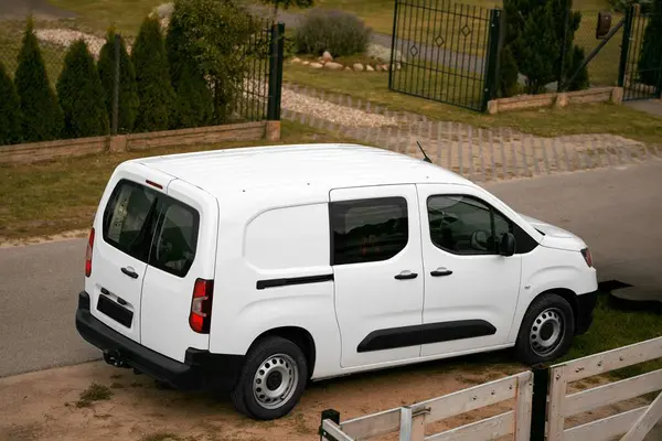 Efficient White Delivery Van on the Move. Modern Cargo Courier.  White Van Transporting Parcels on the Road