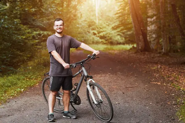 Outdoor Adventure. Man Enjoying Mountain Biking in Natural Landscape. Countryside Cycling. Young Male Biker on a Mountain Bike