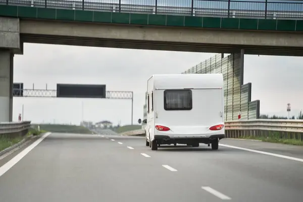 Caravan car travels on the highway in Europe. Recreational Vehicle. Summer RV Road Trips.