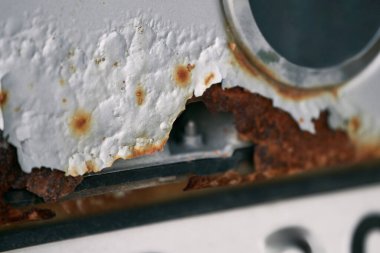 Paslı bir araba cesedi. Paslı bir araba paneli. Çürümüş vücut elementi. Korozyon direnci ve vücut onarımı kavramı. Yol tuzundan hasar