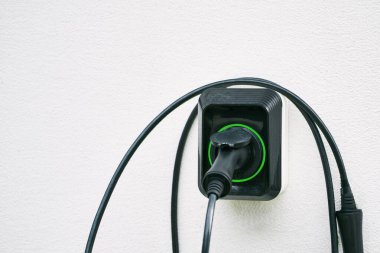 Duvarda elektrikli araç şarj istasyonu var. Enerji EV araba konsepti. Gelecekçi hibrit araç şarj pili