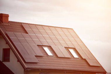 Güneş panelleri olan ev. Sürdürülebilir ve yenilenebilir enerji kavramı.