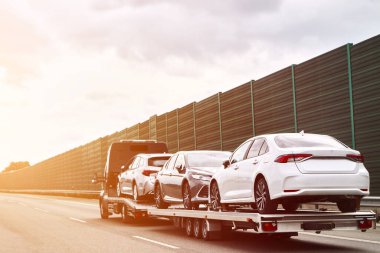 Otoyolda arabalı bir çekici var. Çekici kamyon otobanda araba taşıyor. Araba servisi taşıma konsepti. Yol kenarı Kurtarma.