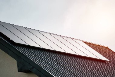 Çatıda Photovoltaic Panelleri olan Modern Ev. Alternatif enerji, tasarruf kaynakları ve sürdürülebilir yaşam tarzı kavramı. Yeşil enerji.