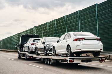 Flatbed kamyonla araba taşıyorum. Otoyolda arabalı bir çekici var. Araç taşımacılığı.