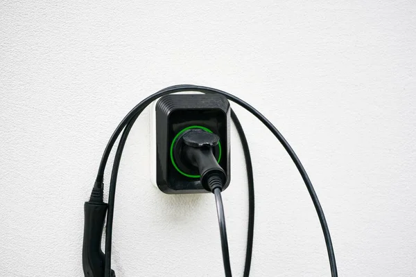 Modern EV electric car charging at home using green electric energy, future of transport concept Wall-Mounted Electric Vehicle Charging Station.