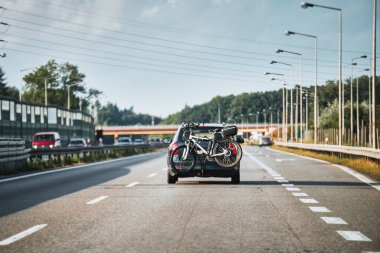 Bagaj bisikleti naklediliyor. Anayolda motosiklet kuyruğu taşıyan arka görüş arabası.