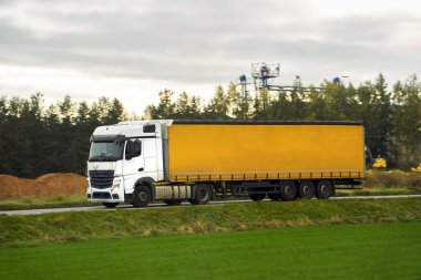 Kamyon otoyolda. Taşıma kamyonu kırsal kesimden geçen yolda. Yer nakliyesi kavramı.