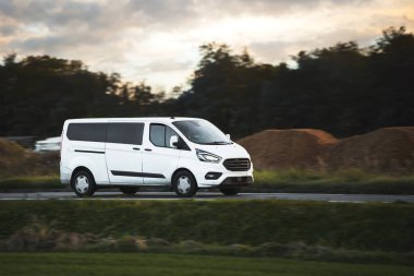 Ticari minibüs banliyö muhallebicilerine kargo teslim ediyor. Taşımacılık, kırsalda mal ve siparişleri paketliyor. Hafif görev kamyonu