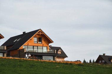 Barnhouse tarzı evler. Konforlu küçük evleri olan bir sokak. Banliyöde yaşıyor. İpotek kredisi kavramı. Modern inşaat. Ahşap evin artıları ve eksileri ve banliyö emlak kavramı.
