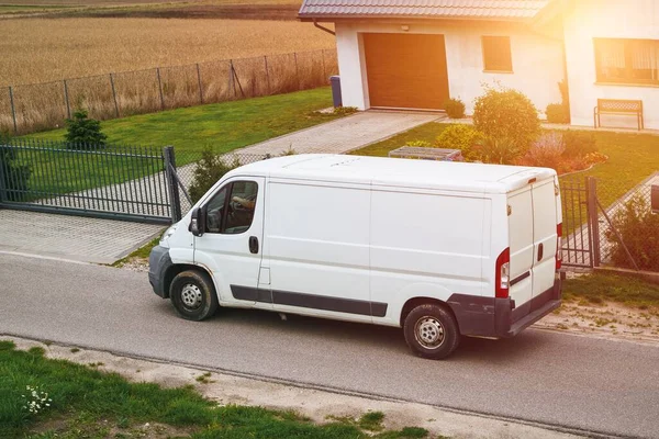 Commercial van delivers cargo to suburban custmers. Shipping parcels goods and orders in the countryside. Light duty truck