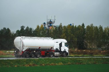 Yakıt Teslimatı. Otoyoldaki Sıvı Yakıt ve Petrol Kargo Yarı Kamyonu. Petrol Ürünleri Taşıma. Akşam Işığında Sıkıştırılmış Gaz Taşıyıcı Kamyonu