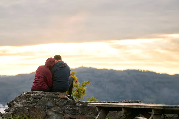 Portrait of a couple from behind. outdoors adventures of friends and couple. Man and woman watching beautiful sunset after hiking.