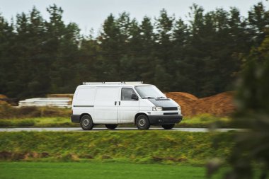 Beyaz minibüs. Suburban Evleri 'ne teslimat. Kırsal bölgedeki Road Kargo Teslimatında ticari minibüs. Hafif Görev Kamyonu Eylemde.