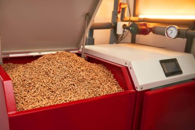 Bir evde ısıyı ve enerjiyi üretmek için doğal ve geri dönüştürülmüş ahşap topaklar yakan modern ve ekolojik bir fırın..