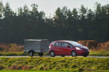 Virajlı yolda bir araba ve kiralık bir karavan. Eşyalarını taşımak için akıllıca bir yol. Kargo 'yu bir araba ve karavanla taşımak. Kullanışlı ve maliyetli bir çözüm.