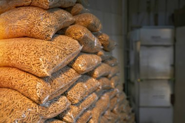 Plastik torbalarda istiflenmiş ahşap topaklar, kışın bir evi ısıtmak için kullanılmaya hazır, alternatif ve sürdürülebilir bir yakıt kaynağı..