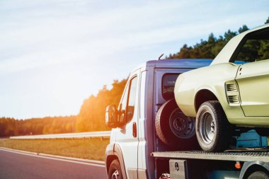 Antika Amerikan kaslı araba gövdesi, kaporta çalışmasından sonra düz kamyonda duruyor. Arabanın boyama gövdesi. Bir kazadan sonra Retro Car 'ı kurtarın. Bir Çekicinin Yardımıyla Klasik Bir Arabayı Yenileme Projesi