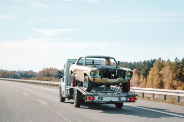 Antika Amerikan kaslı araba gövdesi, kaporta çalışmasından sonra düz kamyonda duruyor. Arabanın boyama gövdesi. Bir kazadan sonra Retro Car 'ı kurtarın. Bir Çekicinin Yardımıyla Klasik Bir Arabayı Yenileme Projesi