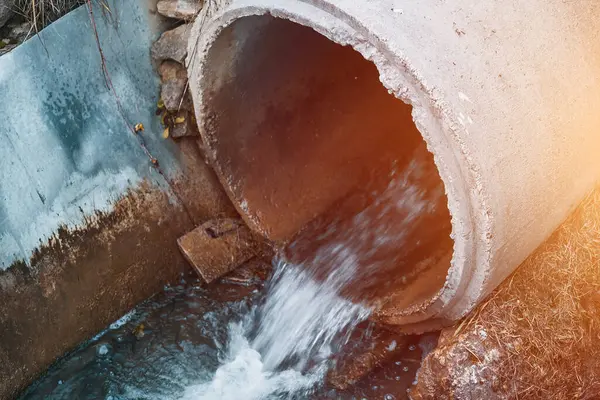 Draining sewage from a pipe into the river. Concept of pollution rivers and ecology. Water pollution, sewer drain pipe dirt sewage water drain. Bad waste water from the city. wastewater management.