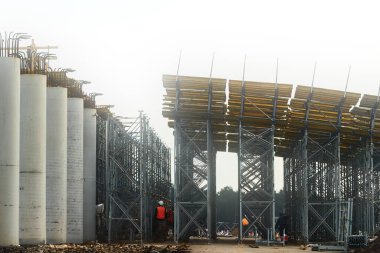 Köprü inşaatı. Yol şu anda trafiği artırmak için çeşitli katlarda yapım aşamasında. Üstgeçit yolu ve çelik elementlerle beton yapıyı destekleyin. Tamamlanmamış inşaat alanı.