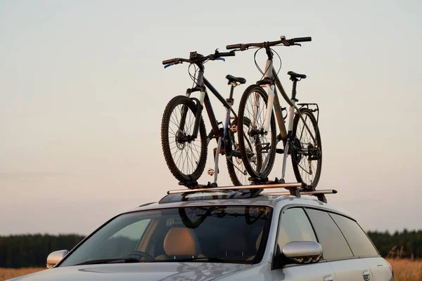 Roof-Mounted Bikes. Car Transporting Sports Equipment. On-the-Go Adventure. Car with Bicycles Mounted on the Roof