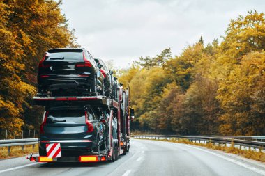 Yolda bozuk motoru olan bir araba, bir kamyon tarafından bir tamirhaneye çekiliyor, yol kenarı yardım ve araç kurtarma hizmetinin bir parçası olarak.