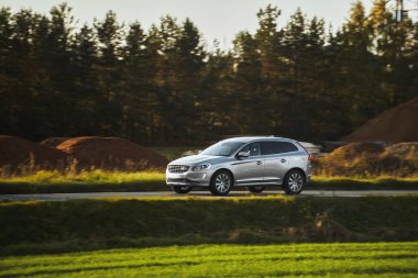 Issız bir yolda hibrit motoru olan bir SUV arabası. Spor ve Aile İçin Modern ve Lüks Bir Geçiş Tasarımı.