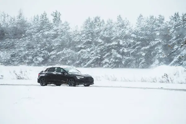 Car on a winter road. Dangerous driving conditions on the highway. Winter tires and undercarriage rust and corrosion concept. Slippery highway.