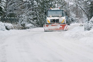 Tuz ve kum ayırıcılı traktör, yol bakımı - kışın kumsal aracı. Belediye hizmetleri sokaklarda buz ve kar eritiyor. Halka açık yollarda tuz karışımı dağıtmak.