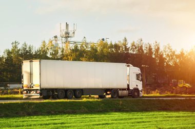 Kamyon otoyolda. Taşıma kamyonu kırsal kesimden geçen yolda. Yer nakliyesi kavramı.