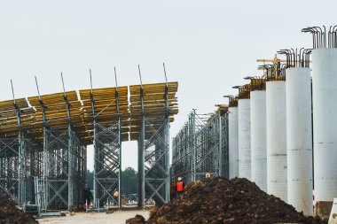 Köprü inşaatı. Yol şu anda trafiği artırmak için çeşitli katlarda yapım aşamasında. Üstgeçit yolu ve çelik elementlerle beton yapıyı destekleyin. Tamamlanmamış inşaat alanı.