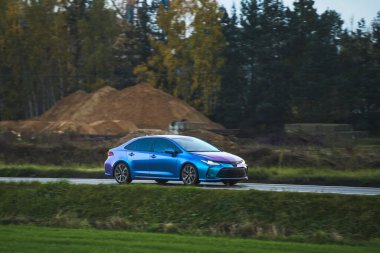 Koruyucu renkli filmlerle kaplı modern Japon sedanı. Yapışkan bukalemun folyoyla kaplı bir araba. Mavi-mor spor araba, mor tonlu vinil film..